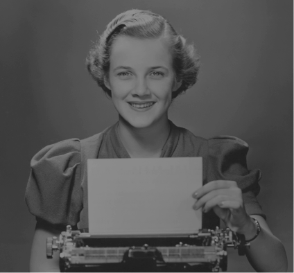 Woman smiling while using a typewriter